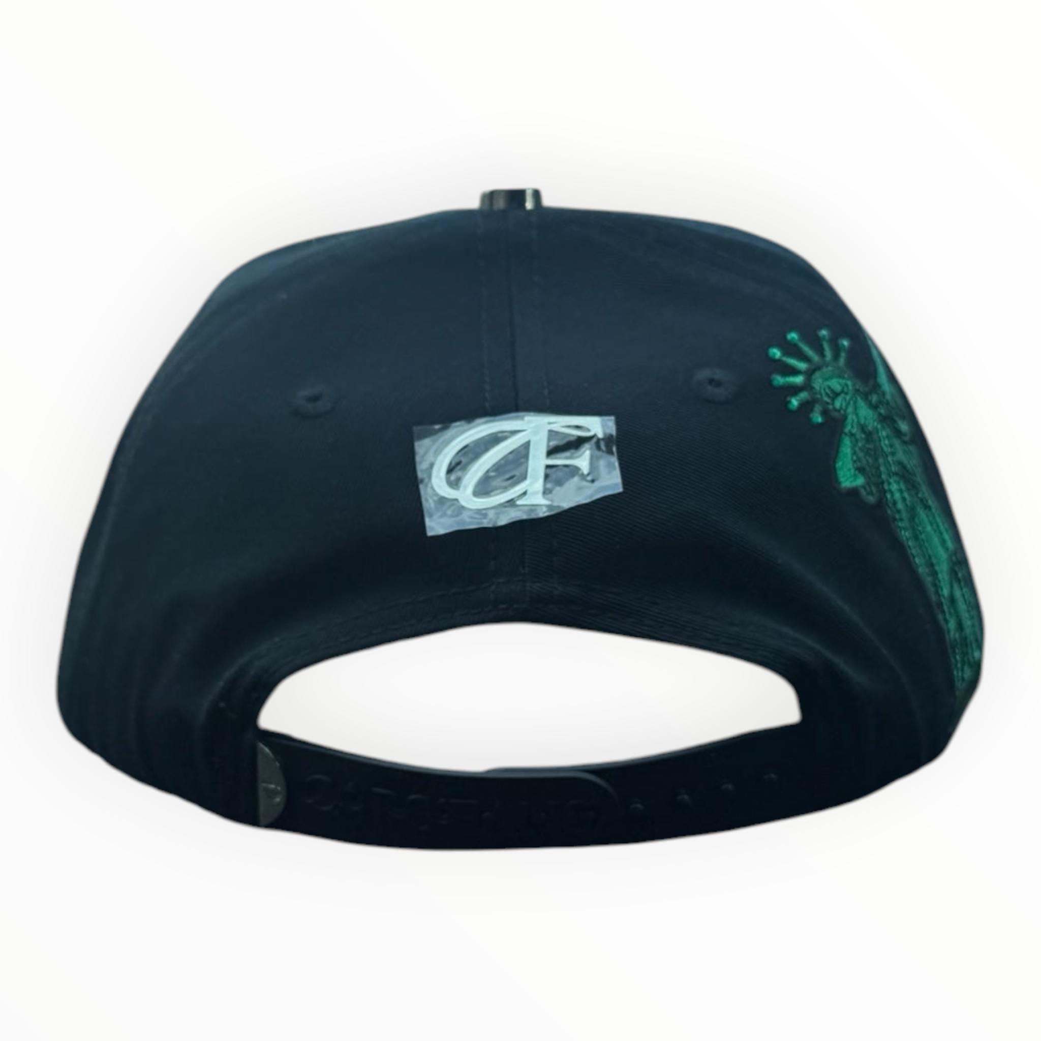 Hype Block black baseball cap with green Statue of Liberty embroidery on the side, resting on a car dashboard.