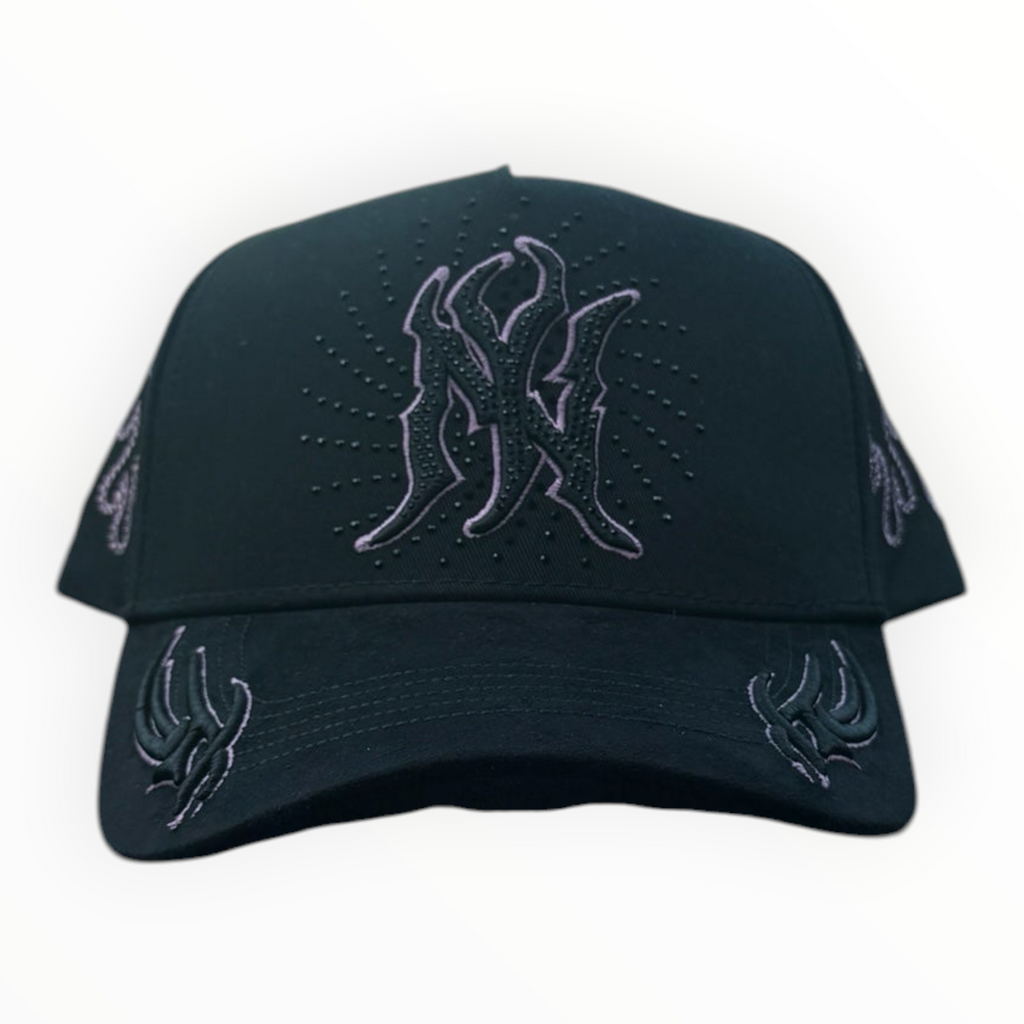 Hype Block black baseball cap featuring pink rhinestone flame embroidery on the crown and brim, sitting on a car dash.
