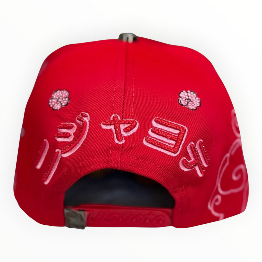 Hype Block red baseball cap featuring detailed pink cherry blossom and white cloud embroidery on the back strap area.