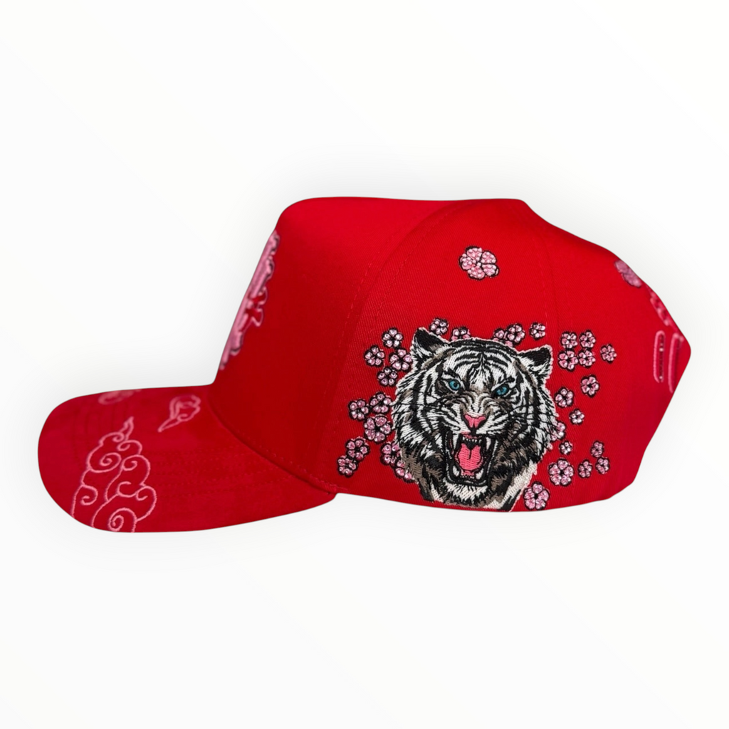 Hype Block red baseball cap featuring detailed side embroidery of a tiger and cherry blossoms with cloud patterns.
