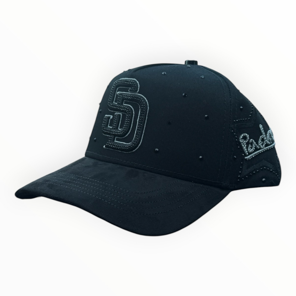 Hype Block black San Diego Padres snapback cap with rhinestone SD logo and stud embellishments on a car dashboard